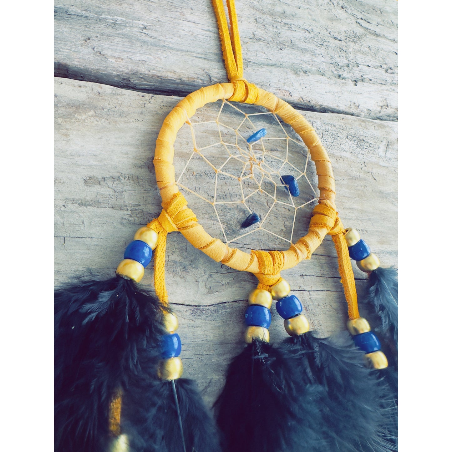 Small handmade Native dreamcatcher with blue lapis-lazuli stones and natural feathers crafted in Quebec.