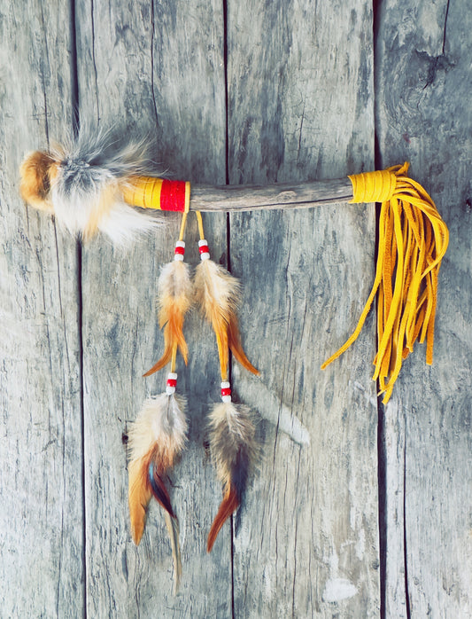 Talking stick with orange and brown feathers, Indigenous traditional design