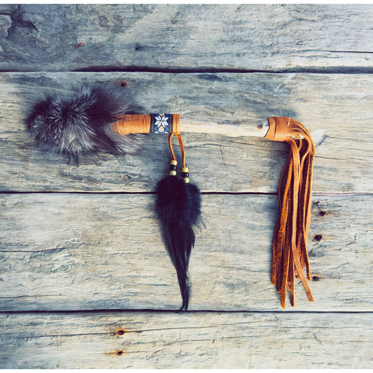 Gros plan sur les éléments symboliques d’un bâton de parole totem fait main par l’artisan ilnu Dave.