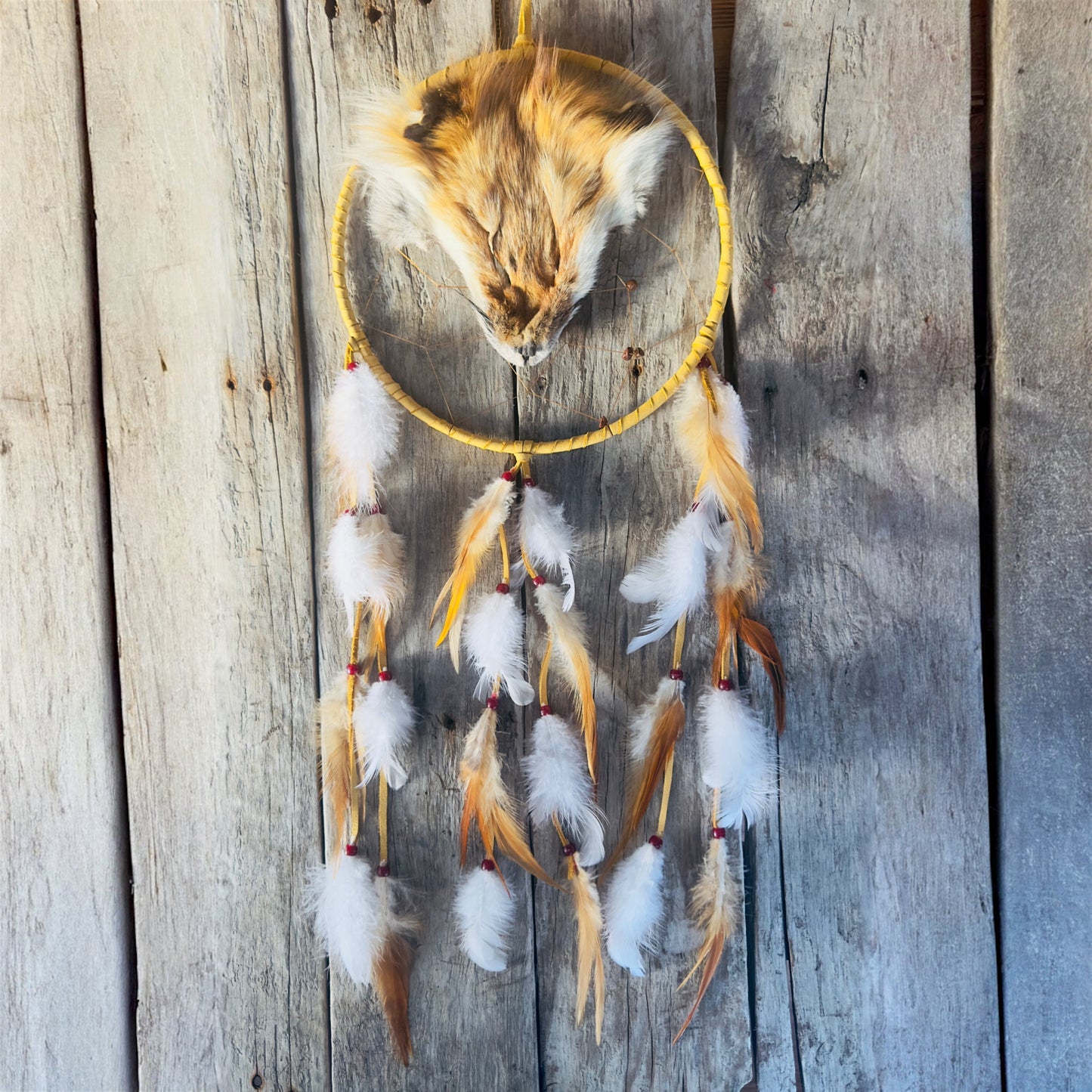 Indigenous dreamcatcher with fox-inspired colors and natural materials