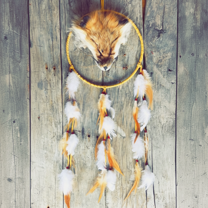 Capteur de rêves artisanal avec tête de renard sculptée et plumes naturelles.