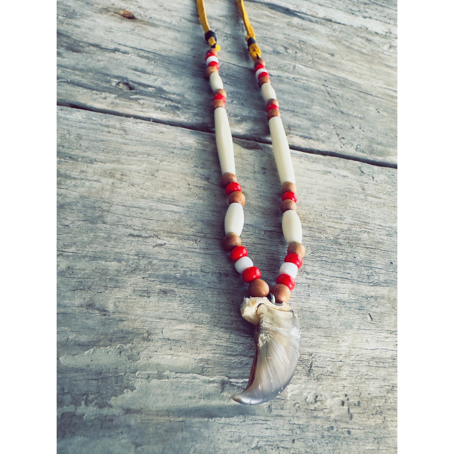 Collier artisanal fait à la main au Québec, orné d’une griffe d’ours authentique et d’éléments naturels.