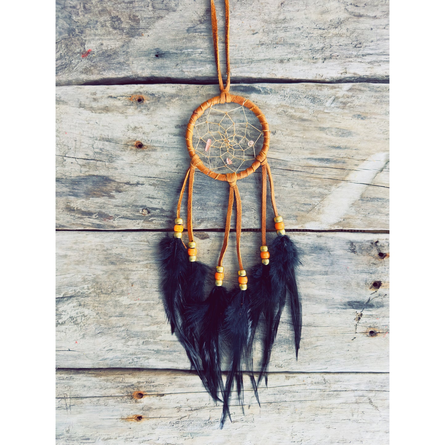 Handcrafted dreamcatcher with brown natural feathers and warm earthy tones, forest-inspired spiritual piece