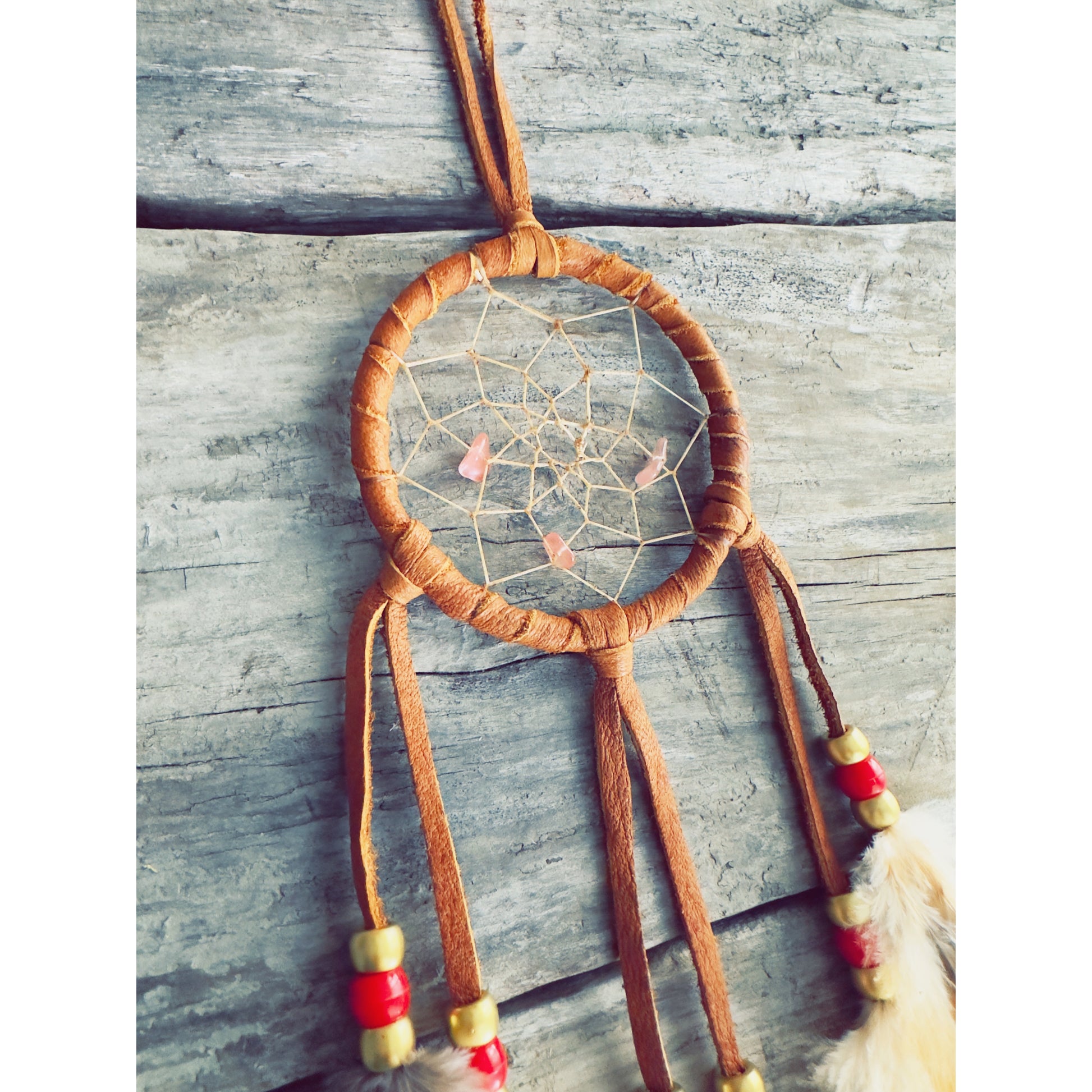 Artisanal dreamcatcher crafted with driftwood and natural stones, symbolic Indigenous-inspired design