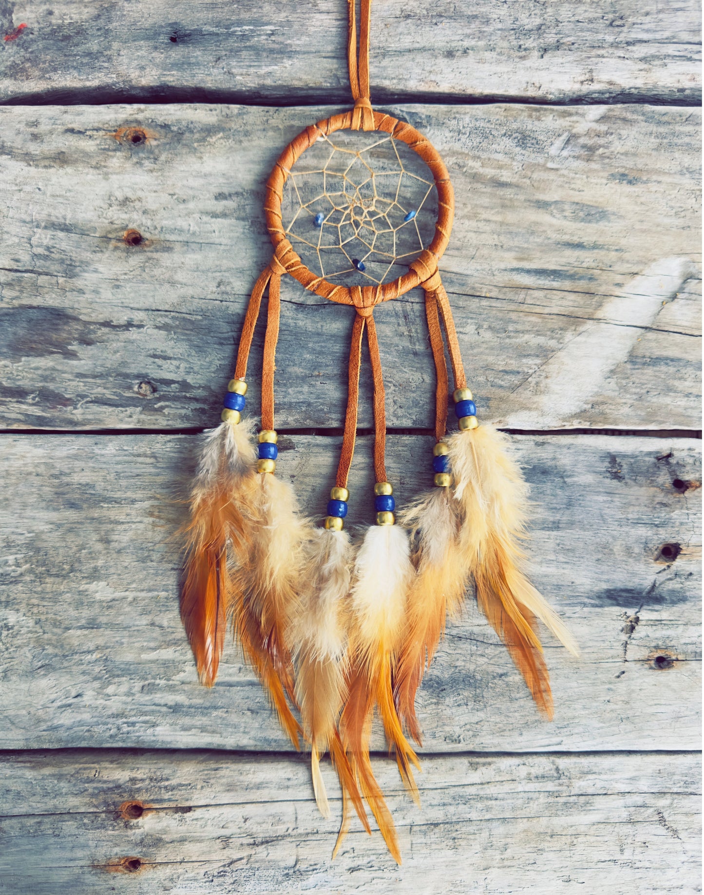 Handcrafted dreamcatcher decorated with natural feathers and traditional materials.