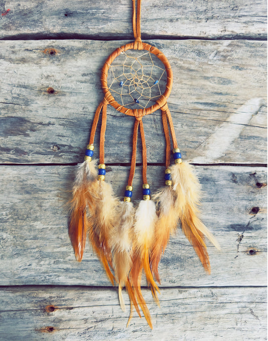 Handcrafted dreamcatcher decorated with natural feathers and traditional materials.